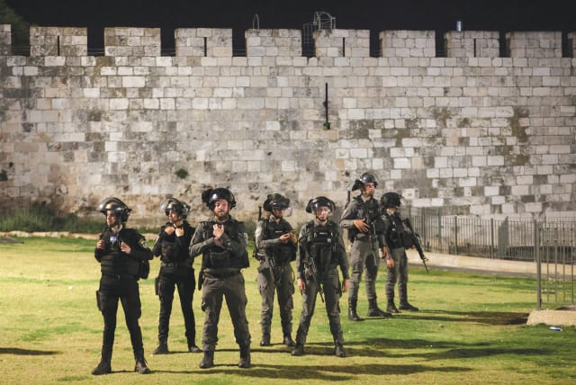 POLICE OFFICERS stand by the walls of Jerusalem’s Old City amid tension with Palestinians during Ramadan earlier this week. (photo credit: RONEN ZVULUN / REUTERS)