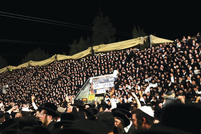 Jewish worshippers sing and dance as they stand on tribunes at the Lag Ba’omer event on Mount Meron on April 29. (photo credit: STRINGER/ REUTERS)
