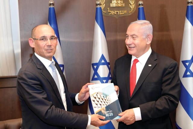 Bank of Israel Governor Prof. Amir Yaron presents the central bank’s Annual Report for 2020 to Prime Minister Benjamin Netanyahu on April 6. (photo credit: AMOS BEN-GERSHOM/GPO)