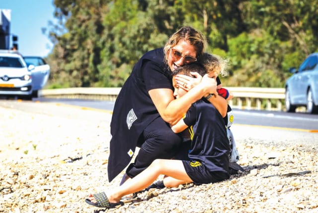 A MOTHER and her child take cover on a road between Ashkelon and Sderot as a siren sounds a warning of incoming rockets fired from the Gaza Strip last week. (photo credit: OLIVIER FITOUSSI/FLASH90)