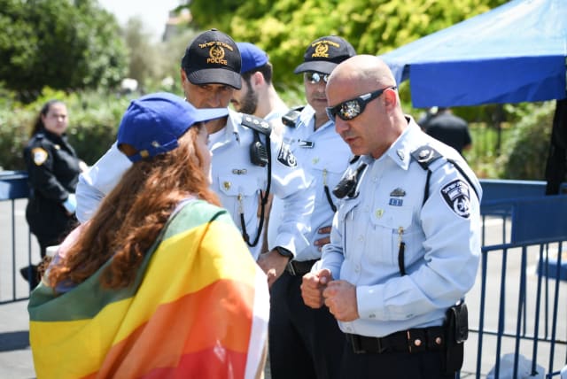 Police officers are seen with an activist at Jerusalem's Gay Pride Parade, on June 3, 2021. (photo credit: POLICE SPOKESPERSON'S UNIT)
