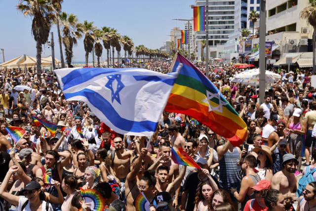 Israeli flag and rainbow flag being waved at Tel Aviv Pride Parade, June 25 2021 (photo credit: GUY YECHIELY)