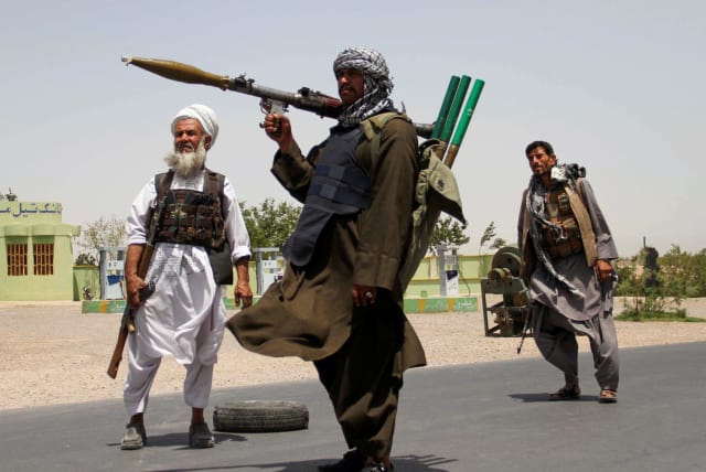 Former Mujahideen hold weapons to support Afghan forces in their fight against Taliban, on the outskirts of Herat province, Afghanistan July 10, 2021. (photo credit: JALIL AHMAD/REUTERS)