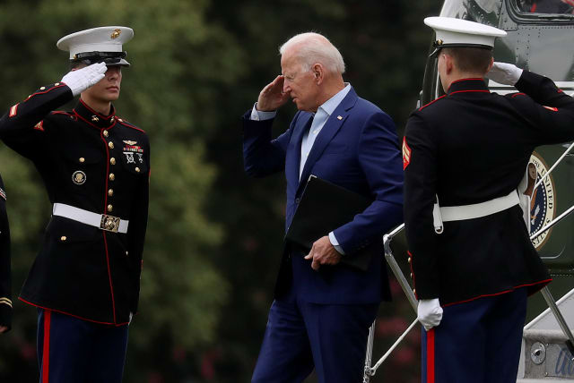  US President Joe Biden returns a salute as he arrives at Fort McNair on his way back to the White House to deliver a statement on Afghanistan, in Washington, U.S., August 16, 2021. (photo credit: LEAH MILLIS/REUTERS)