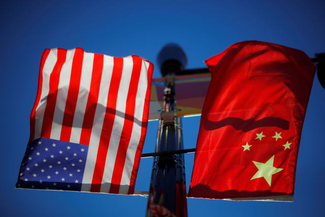  The flags of the United States and China fly from a lamppost in the Chinatown neighborhood of Boston, Massachusetts, US, November 1, 2021. (photo credit: REUTERS/BRIAN SNYDER)