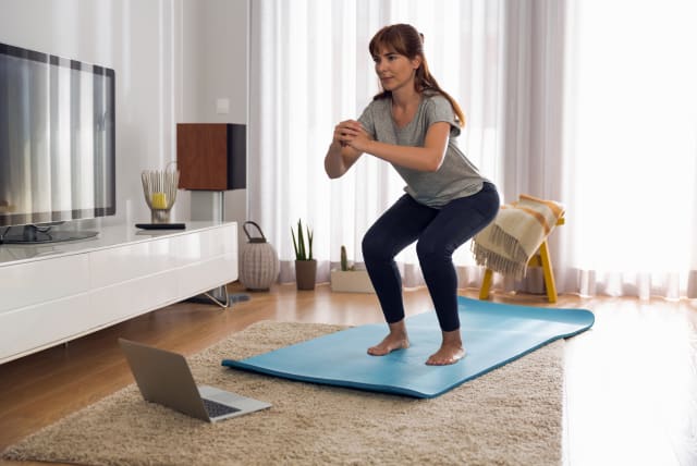 Woman doing exercise at home (photo credit: INGIMAGE)