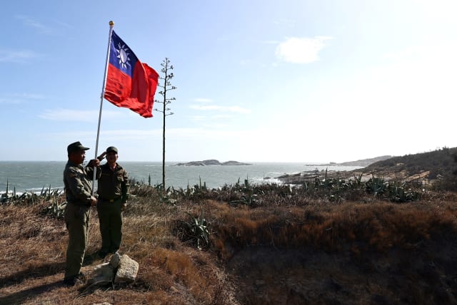  Veterans take part in a flag raising ceremony at a former military post on Kinmen, Taiwan, October 15, 2021. Sitting on the front line between Taiwan and China, Kinmen is the last place where the two engaged in major fighting, in 1958 at the height of the Cold War. (photo credit: REUTERS/ANN WANG)