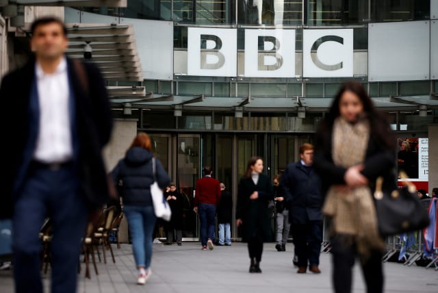 Pedestrians walk past a BBC logo at Broadcasting House in London, Britain, January 29, 2020. (photo credit: REUTERS/HENRY NICHOLLS/FILE PHOTO)