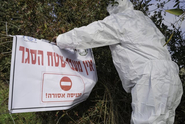  Workers in protective gear seen in Moshav Givat Yoav, in northern Israel, December 29, 2021, following an outbreak of avian influenza (photo credit: MICHAEL GILADI/FLASH90)