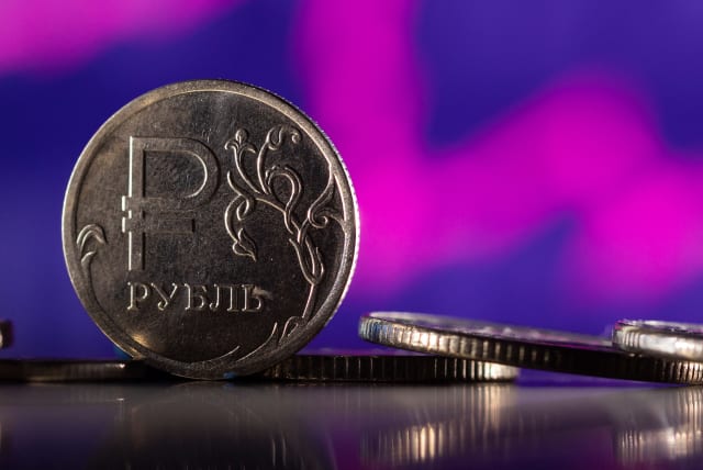  Russian Rouble coins are seen in front of displayed descending stock graph in this illustration taken, February 24, 2022. (photo credit: REUTERS/DADO RUVIC/ILLUSTRATION)