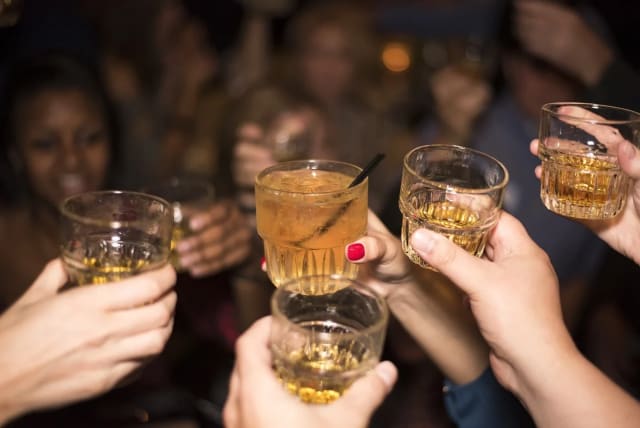  People raise a toast with whiskey glasses. Purim and St. Patrick's Day have drinking in common. (photo credit: PIXABAY)