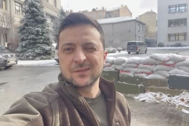  UKRAINIAN PRESIDENT Volodymyr Zelensky winks in a video statement with sand bags behind him in Kyiv, in this still image obtained from social media.  (photo credit: Instagram/Volodymyr Zelensky/via Reuters)