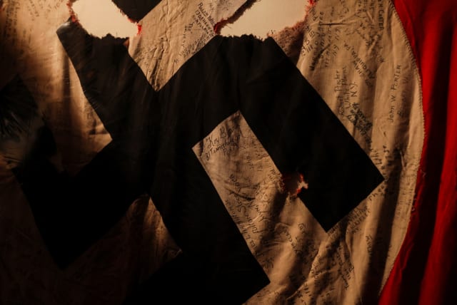  A Nazi Swastika flag captured and signed by members of a black segregated U.S. Army unit in World War II is displayed amid the collection of Elizabeth Meaders, New York, February 2, 2022. (photo credit: REUTERS/MIKE SEGAR)