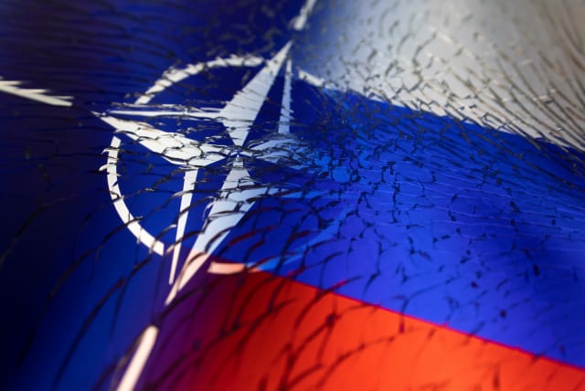 NATO and Russian flags are seen through broken glass this illustration taken April 13, 2022. (photo credit: REUTERS/DADO RUVIC/ILLUSTRATION)