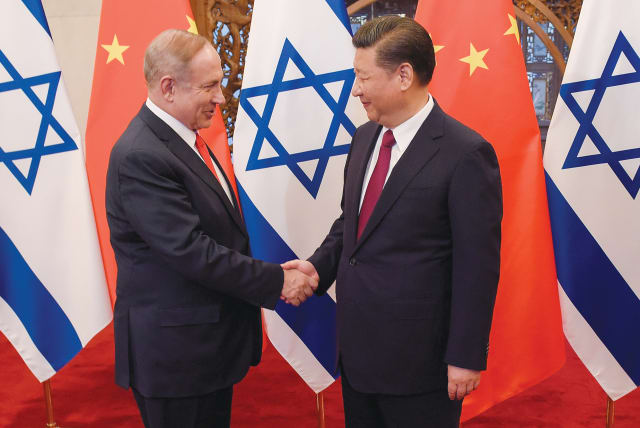  THEN-PRIME MINISTER Benjamin Netanyahu and Chinese President Xi Jinping shake hands ahead of talks in Beijing, in 2017. ‘Beijing is not a friend. It is time to pivot away from Beijing,’ say the writers.  (photo credit: Etienne Oliveau/Reuters)