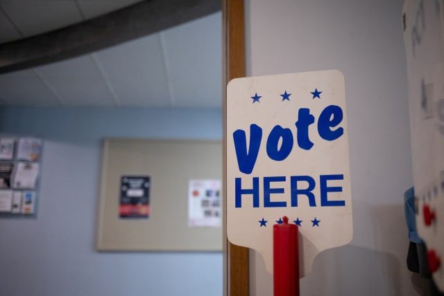  A 'Vote Here' sign is seen at a precinct the day before Michigan Democrats and Republicans choose their nominees to contest November's congressional elections, which will determine which party controls US House of Representatives for next two years, in Birmingham, Michigan, US August 1, 2022. (photo credit: REUTERS/EMILY ELCONIN)