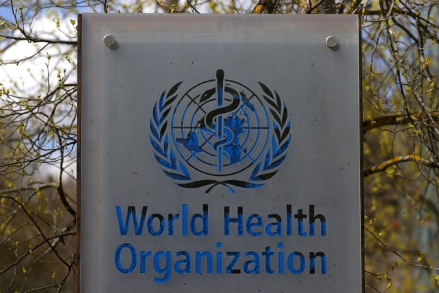 A logo is pictured outside a building of the World Health Organization (WHO) during an executive board meeting on update on the coronavirus disease (COVID-19) outbreak, in Geneva, Switzerland, April 6, 2021. (photo credit: REUTERS/DENIS BALIBOUSE/FILE PHOTO)