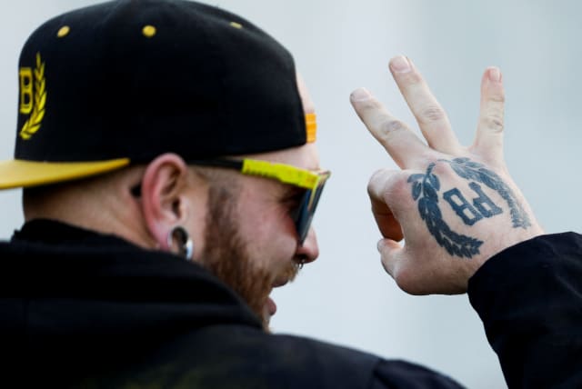  A member of the Proud Boys gestures in front of the Oregon State Capitol during a protest in support of the January 6th attack on the US Capitol in Washington, in Salem, Oregon, US, January 8, 2022.  (photo credit: REUTERS/JOHN RUDOFF)