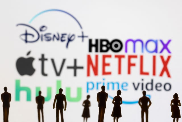  Toy figures of people are seen in front of the displayed Disney +, HBO Max, Apple TV, Netflix, Hulu and Prime video logos, in this illustration taken January 20, 2022.  (photo credit: REUTERS/DADO RUVIC/ILLUSTRATION)