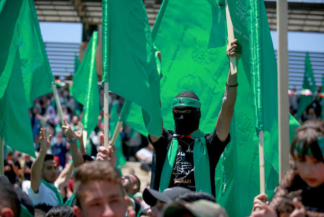 Palestinian students supporters of the Hamas movement wave the movement's flag during a rally at Birzeit University, near the West Bank city of Ramallah, May 19, 2022 (photo credit: FLASH90)