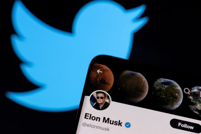  : Elon Musk's twitter account is seen on a smartphone in front of the Twitter logo in this photo illustration taken, April 15, 2022. (photo credit: REUTERS/DADO RUVIC/ILLUSTRATION)