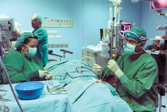  Surgeons perform surgery on a patient at Assuta Medical Center in Tel Aviv.  (photo credit: Moshe Milner/GPO)