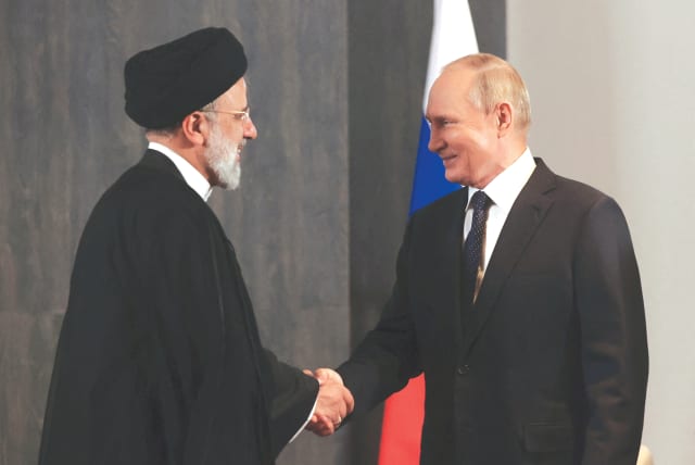 RUSSIAN PRESIDENT Vladimir Putin shakes hands with Iranian President Ebrahim Raisi during a meeting in September (photo credit: SPUTNIK/REUTERS)