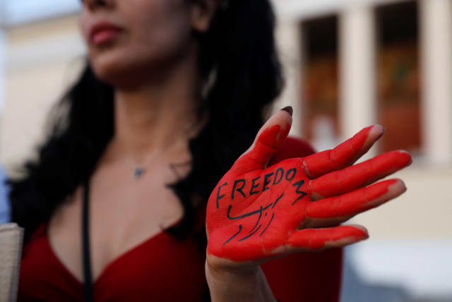  A woman with her hand painted with the word "Freedom" takes part in a protest following the death of Mahsa Amini, in Athens, Greece, October 1, 2022. (photo credit: REUTERS/COSTAS BALTAS)