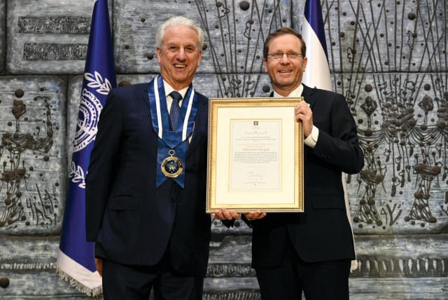  Michael D. Siegal receives the Israeli Presidential Medal of Honor and citation from President Isaac Herzog at the President’s Residence on December 11.  (photo credit: HAIM ZACH/GPO)