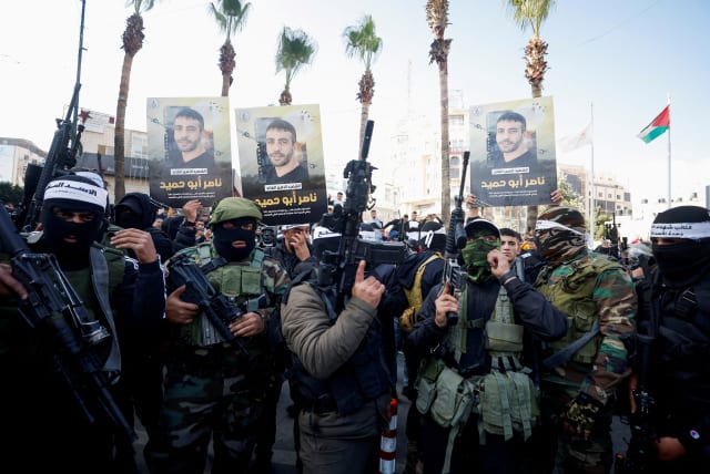   Palestinians including gunmen gather during a protest following the death of senior Palestinian militant Nasser Abu Hmaid who was jailed by Israel and died in an Israeli hospital where he had been moved to after his health deteriorated, in Ramallah in the West Bank December 20, 2022. (photo credit: REUTERS/MOHAMAD TOROKMAN)