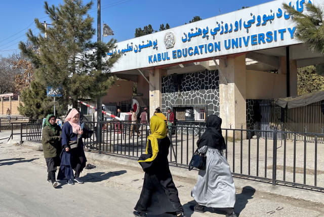 Female students walk in front of the Kabul Education University in Kabul, Afghanistan, February 26, 2022.  (photo credit: REUTERS/STRINGER/FILE PHOTO)