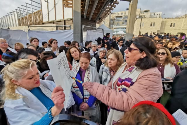  Women of the Wall read from a Torah scroll at the Western Wall on the seventh day of Hanukkah, December 25, 2022. (photo credit: WOMEN OF THE WALL)