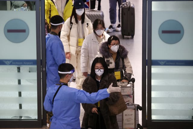  A South Korean soldier wearing personal protective equipment (PPE) guides a group of Chinese tourists for coronavirus disease (COVID-19) tests upon their arrival at the Incheon International Airport in Incheon, South Korea, January 4, 2023. (photo credit: REUTERS/KIM HONG-JI)