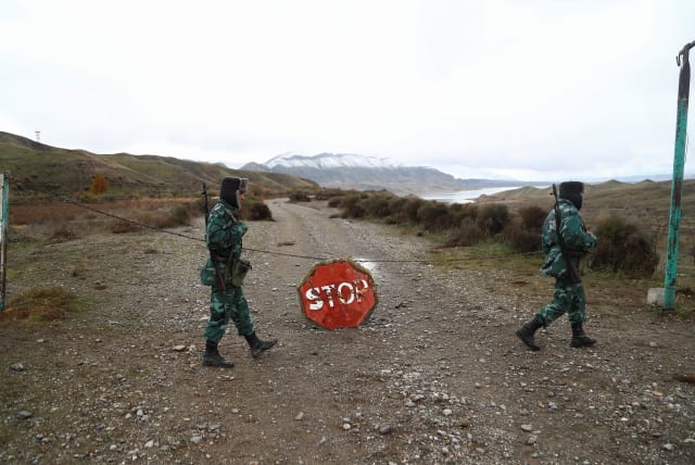  Azeri service members guard the area, which came under the control of Azerbaijan's troops following a military conflict over Nagorno-Karabakh against ethnic Armenian forces and a further signing of a ceasefire deal, on the border with Iran in Jabrayil District, December 7, 2020 (photo credit: AZIZ KARIMOV/REUTERS)