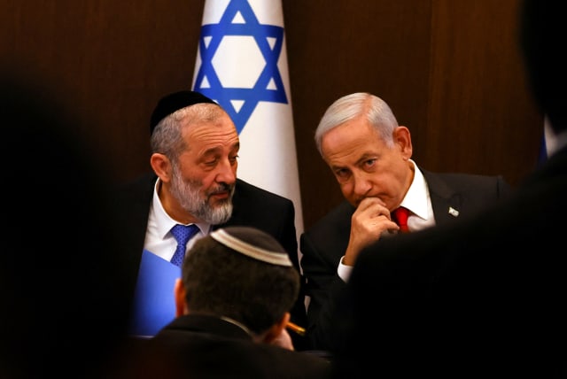  Israeli Prime Minister Benjamin Netanyahu speaks with Interior and Health Minister Aryeh Deri at a weekly cabinet meeting at the Prime Minister's office in Jerusalem, January 8, 2023 (photo credit: REUTERS/Ronen Zvulun/Pool)