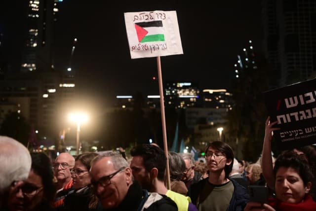 Palestinian flag on sign reading "justice for all from the Jordan to the sea" at anti-Netanyahu protest in Tel Aviv, January 7, 2023 (photo credit: AVSHALOM SASSONI/MAARIV)