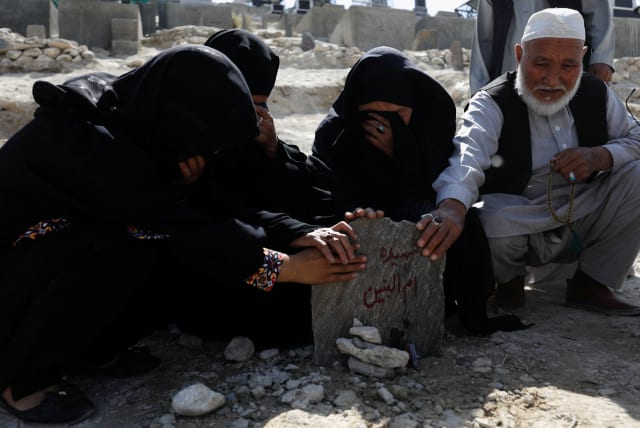  The family members of Um al-Banin, who was killed in a suicide attack in a tutoring center in Dasht-e-Barchi district in the west of Kabul, pray at her grave in Kabul (photo credit: REUTERS)