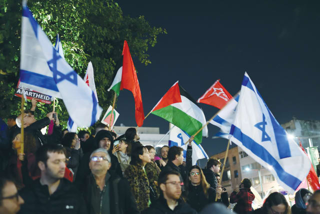  PALESTINIAN AND Israeli flags are waved at a demonstration protesting against the policy of the new Netanyahu government, in Tel Aviv, earlier this month.  (photo credit: GILI YAARI/FLASH90)