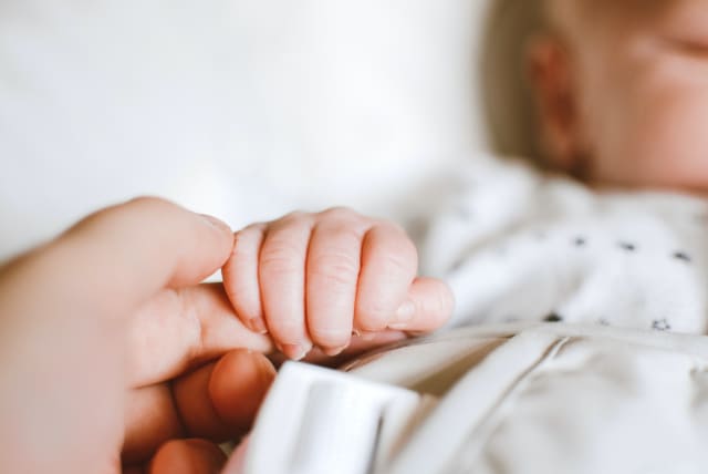  Infant holding their parent's hand (illustrative) (photo credit: PEXELS)