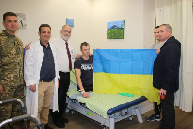  Right to left: Ukrainian Ambassador Yevgen Korniychuk, Ukrianian soldiers holding a flag, Dr. Hagai Amir, Dr. Sergey Kotikov, and the military annex of the embassy. (photo credit: PUBLIC RELATIONS)