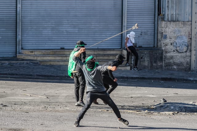 Palestinians clash with Israeli security forces during a protest in the West Bank town of Al Ram, north of Jerusalem, January 27, 2023.  (photo credit: JAMAL AWAD/FLASH90)