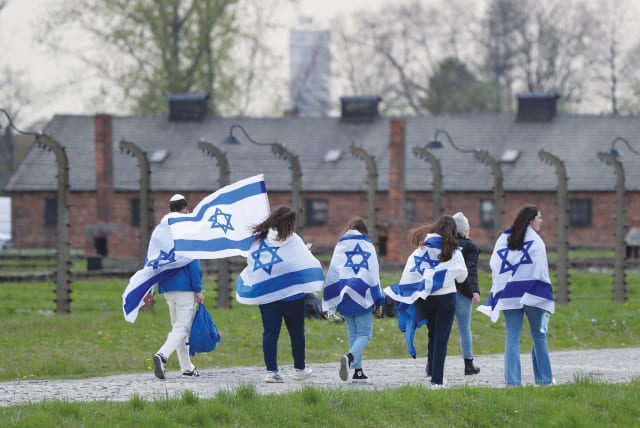  MARCHERS WRAPPED in Israeli flags attend the annual March of the Living at the former Auschwitz II-Birkenau death camp, near Oswiecim, Poland. (photo credit: REUTERS/KACPER PEMPEL)