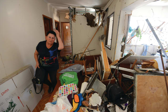  A WOMAN in an Ashdod home ponders the damage from a Gazan rocket attack in May 2021. Iranian activists infiltrated WhatsApp and Telegram groups and inflamed tensions between Jews and Arabs during Operation Guardian of the Walls, says the writer. (photo credit: AVI ROCCAH/FLASH90)