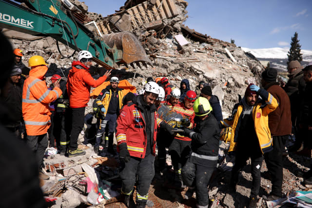  Rescuers carry a survivor at the site of a collapsed building, in the aftermath of a deadly earthquake in Kahramanmaras, Turkey February 8, 2023.  (photo credit: STOYAN NENOV/REUTERS)