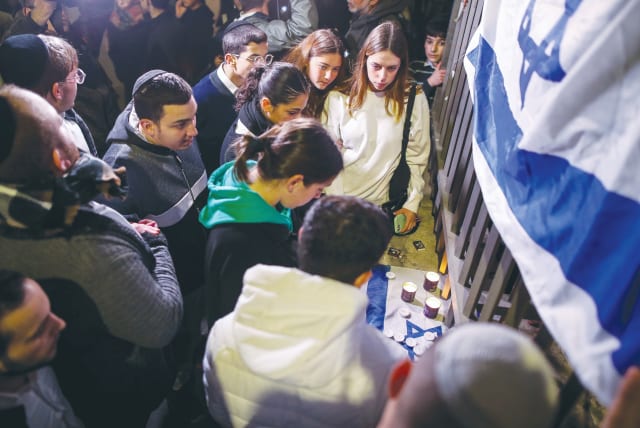  MEMORIAL CANDLES are lit after Shabbat, at the scene of a terror attack on a synagogue on a Friday night last month, in which seven people were killed, in Jerusalem’s Neveh Ya’acov neighborhood. (photo credit: NOAM REVKIN FENTON/FLASH90)
