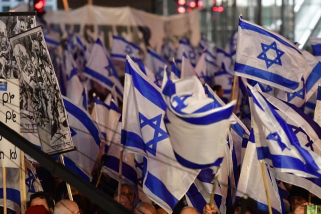 People gather with Israeli flags to protest against the government and the proposed judicial reforms, Tel Aviv, February 18, 2023. (photo credit: AVSHALOM SASSONI/MAARIV)