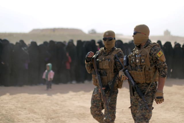  Fighters of Syrian Democratic Forces (SDF), walk together near Baghouz, Deir Al Zor province, Syria March 5, 2019.  (photo credit: REUTERS/RODI SAID)