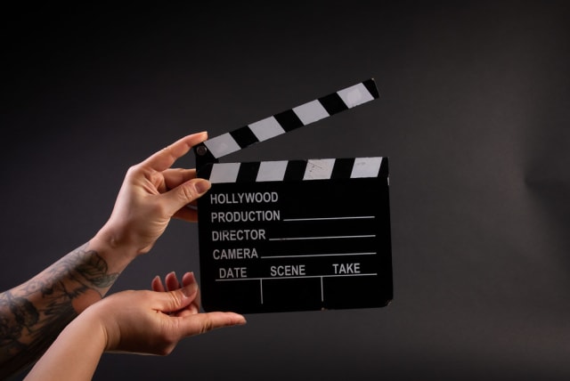  Illustrative image of person holding professional movie clapper board (photo credit: FLICKR)