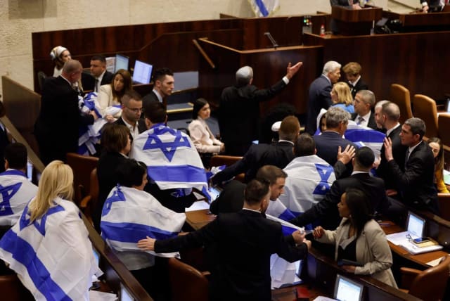  Israeli opposition MKs are seen putting on Israeli flags in the Knesset plenum ahead of a planned vote on judicial reform, in Jerusalem, on February 20, 2023. (photo credit: MARC ISRAEL SELLEM/THE JERUSALEM POST)