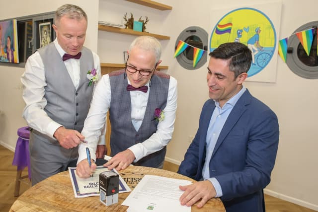 Yuval Reubani and Simon Wrigley sign a civil marriage certificate in honor of Family Day, Ramat Gan, February 21, 2023. (photo credit: CADIA LEVY, RAMAT GAN MUNICIPALITY)